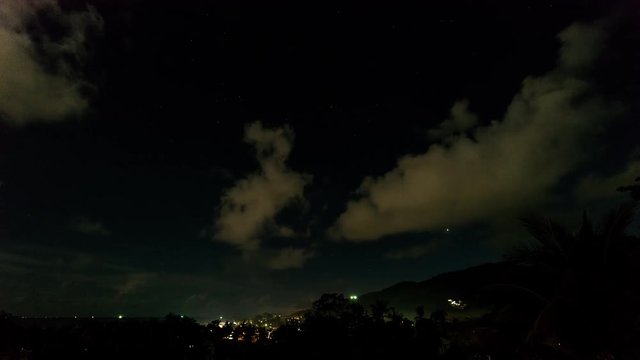 Clouds, stars and thunderstorm in the sky over island. 4k time lapse