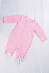 Pink footed baby girl pajama on wood.