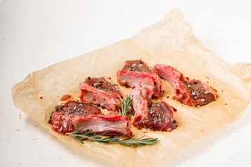 Raw lamb chops on a paper prepared for cooking on a marble table