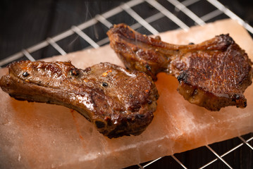 Tow lamb chops cooking at himalayan rock salt block