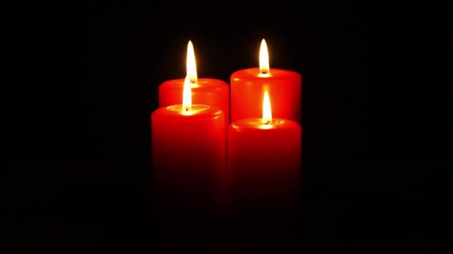 four red christmas candles burning