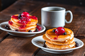Fresh, homemade pancakes with honey, a cup of hot, fresh coffee on a wooden background. Tasty breakfast. Pancakes with syrup