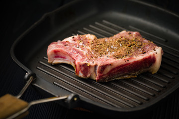Close-up of Pork Steak Cooking On a Grill Pan With Herbs And Rock Salt.