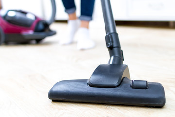 A vacuum cleaner. Room cleaning. Young woman cleaning the floor in the living room with a vacuum...