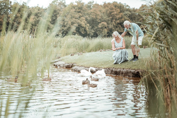 Fototapeta premium Close to water. Handsome male person standing near his wife while enjoying weekend on nature