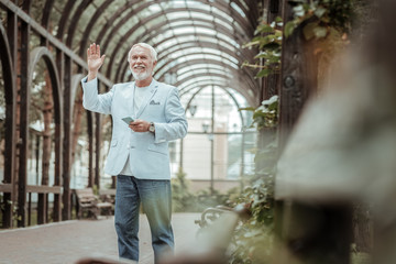 Glad to meet you. Cheerful man standing in arch while going to have romantic mood