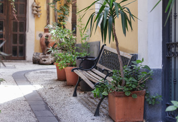 Fototapeta na wymiar Bench and plants in tubs in the courtyard of the house