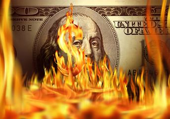 Conceptual image of burning dollar bill and fire flames
