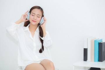 Beautiful portrait asian young woman happy enjoy and fun listen music with headphone sitting in living room, lifestyle of girl relax sound radio with earphone, leisure and technology concept.