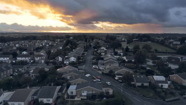 Aerial view, rise up move. Stunning sunset behind residential area of small town, Tarvin in Cheshire.