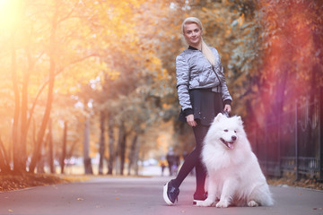 Naklejka na ściany i meble Lovely girl on a walk with a beautiful dog
