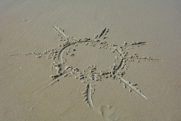 Sonne in den nassen Sand am Strand gemalt   