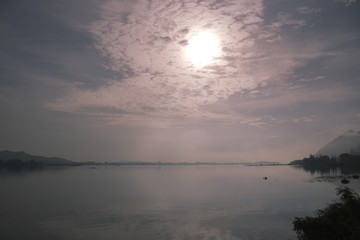 The sun with the clouds reflected in the river.
