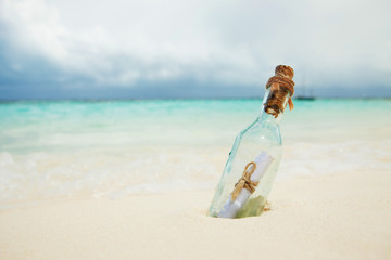 A letter in a bottle on the beach. Island lifestyle. White sand, crystal-blue sea of tropical beach. Ocean beach relax, travel to islands