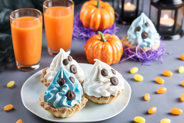Halloween sweet treats, party food concept. White and blue cakes with faces close up.