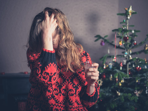 Stressed woman by christmas tree