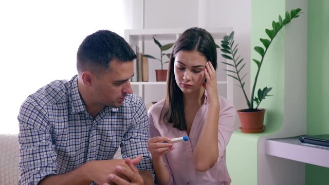 rageful family couple with positive pregnancy test learned about unplanned pregnant and upset by results in bright indoors at home