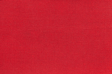 Dark red background from a textile material with wicker pattern, closeup.
