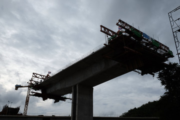 Under-construction of concrete high way with heavy equipment.