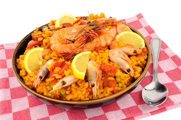 Bowl of fresh seafood paella with shell on prawns isolated on a background