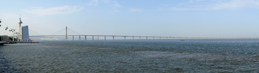 Obraz premium The panoramic view of Vasco da Gama bridge and river Tagus promenade. Lisbon. Portugal