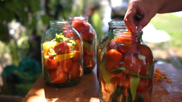 Woman Puts Tomatoes In Jar For Preservation, Preparation Of Canned Vegetables