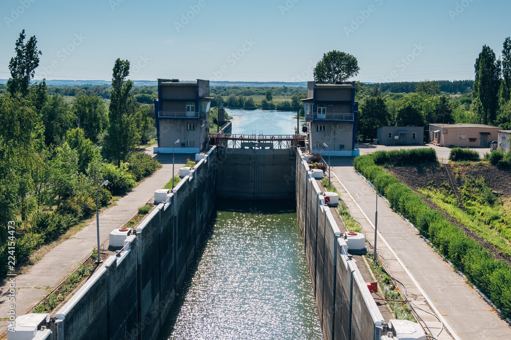 Wall mural gateway lock sluice construction on river dam for passing ships and boats