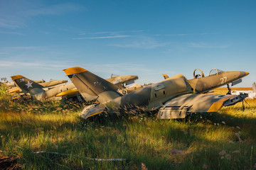 Abandoned broken old military fighter airplanes on grassy ground