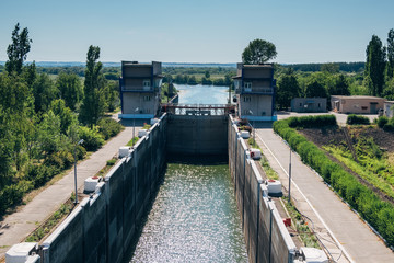 Gateway lock sluice construction on river dam for passing ships and boats 