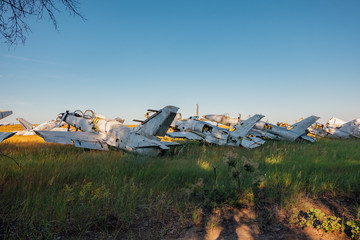 Abandoned broken old military fighter airplanes on grassy ground