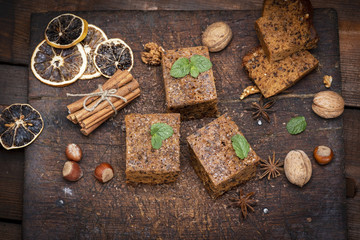 baked square slices of a pie whith nuts on a white wooden board, sponge cake