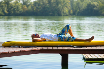 SUP surfer lies on the sup board, relaxes and enjoys life