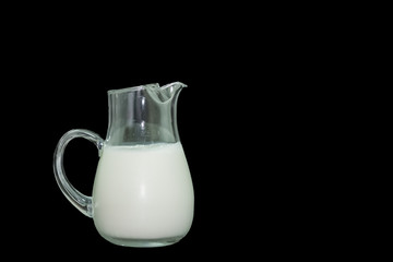 Glass bottle with milk inside with black background.