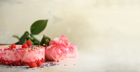 Pink roses and raspberry cake with fresh berries, rosemary, dry flowers on concrete background. Copy space for your text. Birthday party concept. Banner