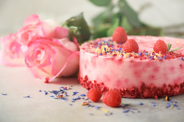 Pink roses and raspberry cake with fresh berries, rosemary, dry flowers on concrete background. Copy space for your text. Birthday party concept