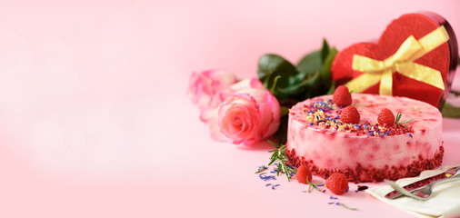 Gift boxes in shape of heart, roses, raspberry cake with fresh berries, rosemary and dry flowers on...