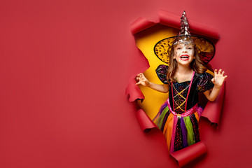 Happy Halloween. Laughing funny child girl in a witch costume of halloween looking, smiling and...