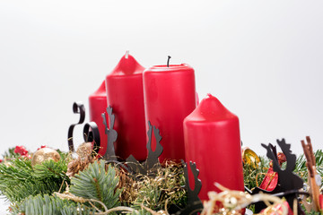 Four traditional red advent candles with christmas decoration. Isolated on white background