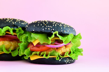 Macro view of tasty burger with beef, cheese, lettuce, onion, tomatoes on pink background. Close up banner. Unhealthy diet concept and copy space