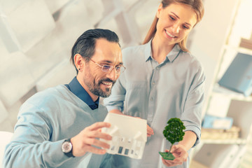 Future estate. Pleased brunette male expressing positivity while thinking about modern city