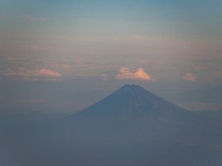 Mount Fuji in summer with cloudy sky and morning light. Aerial view from an airplane. - Max zoom version