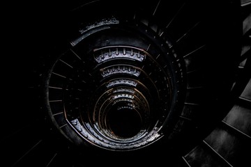 Downward view of dark spiral staircase