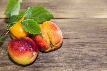 Food, fresh fruit, sweet dessert. Three ripe fresh vitamin juicy peach on a wooden table background in a rustic style