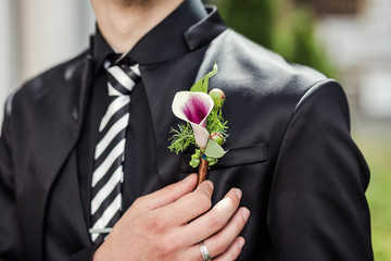 man holding bouquet in hands, groom getting ready in the morning before wedding ceremony