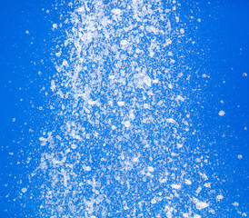 Splashing water from a fountain against the blue sky