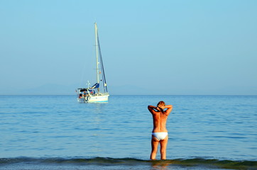 Woman looking at the horizon with the calm of the sea, in Zahara de los Atunes beach, Cadiz
