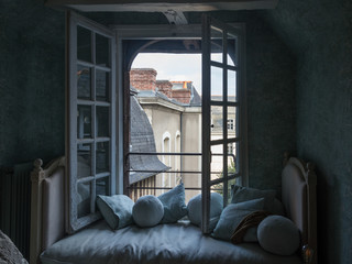 Cojines, sofá y Ventana vintage con vistas en una ciudad de la Bretaña francesa  Francia, Europa © gurb101088