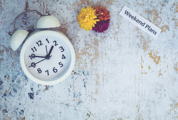 Weekend Plans Fall time concept with white clock and flowers, flat lay