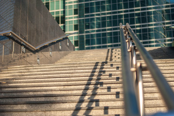 view from below on the staircase leading upwards against the background of modern office buildings