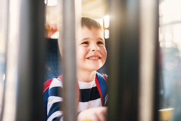 Small beautiful boy is happy about his first ride with a bus.